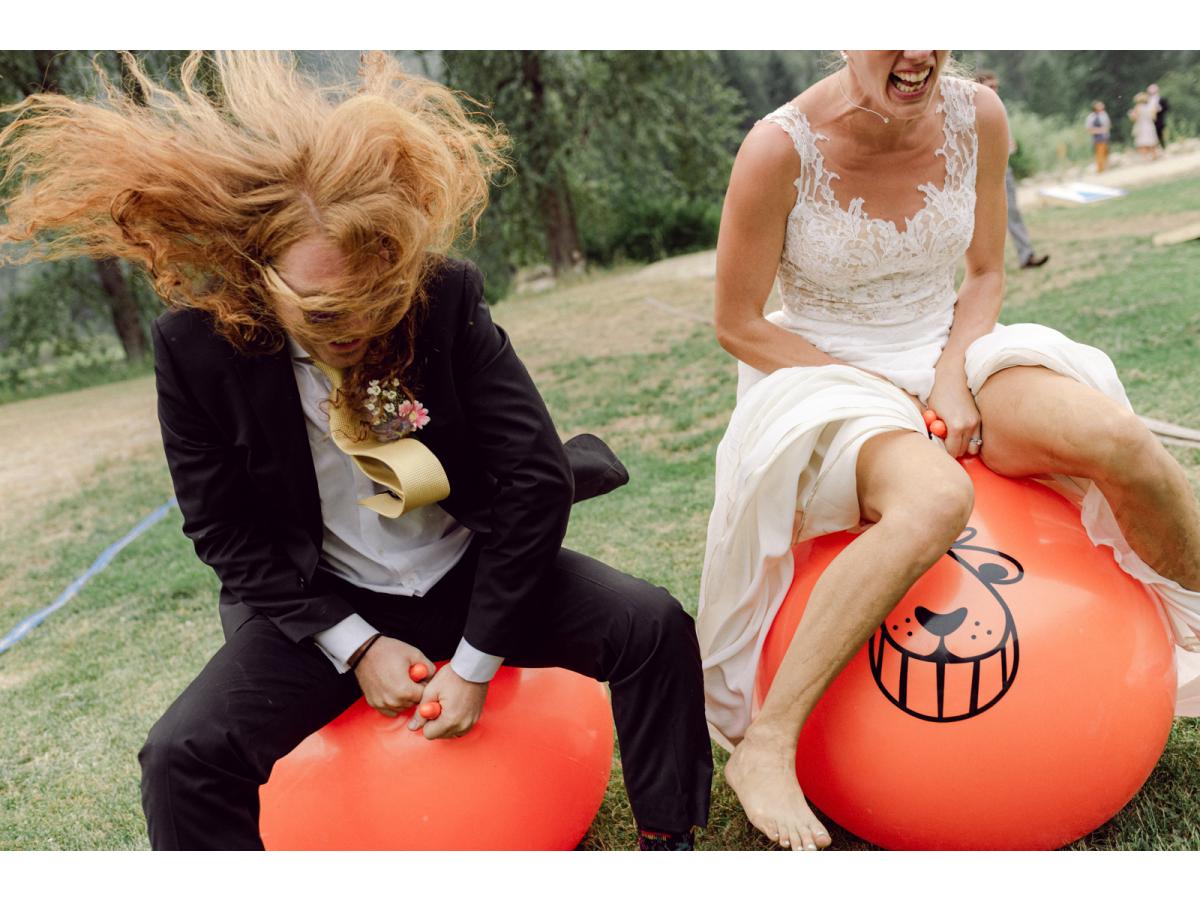 bride and groom bounce on orange bouncy ball